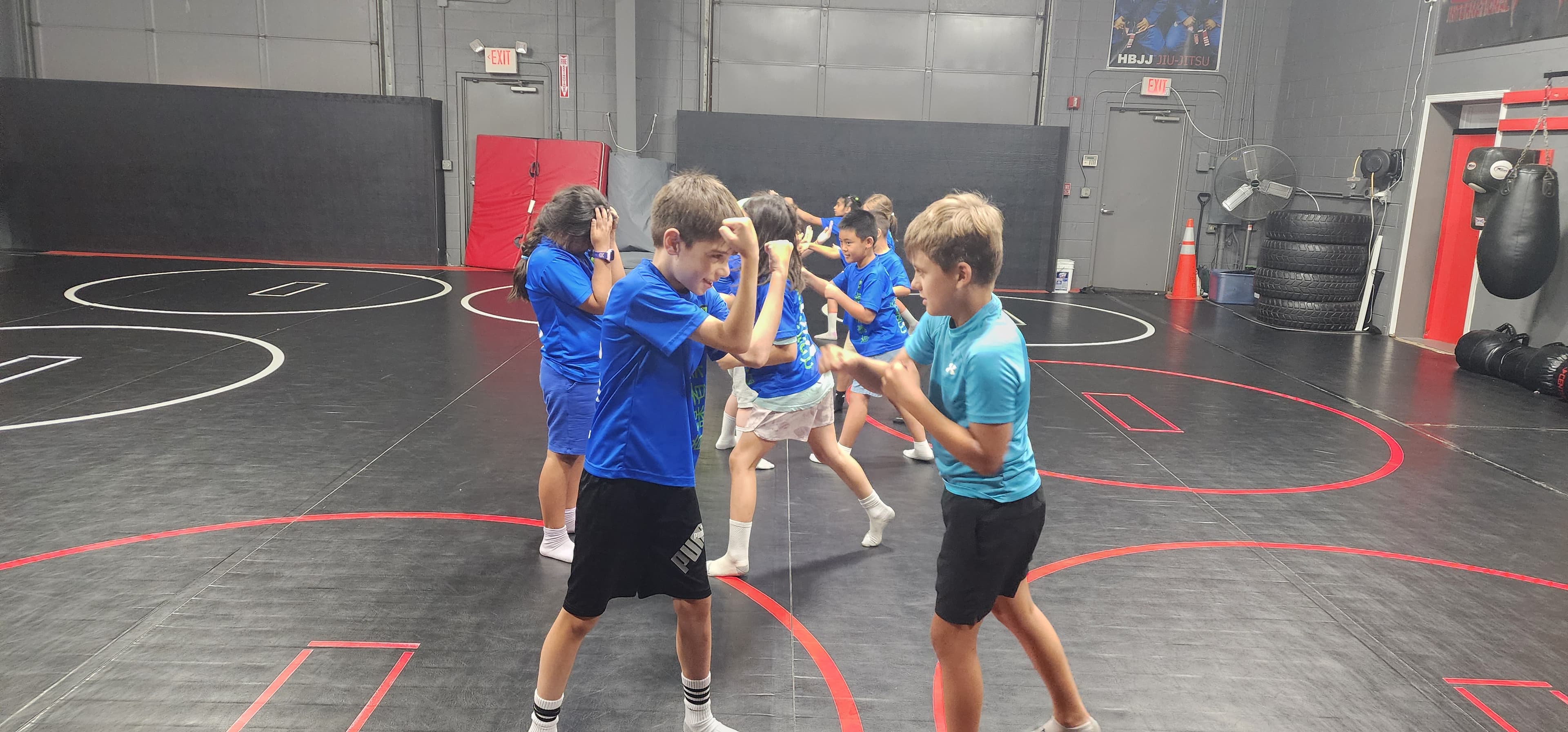 Children practicing a movement drill on the indoor training mats